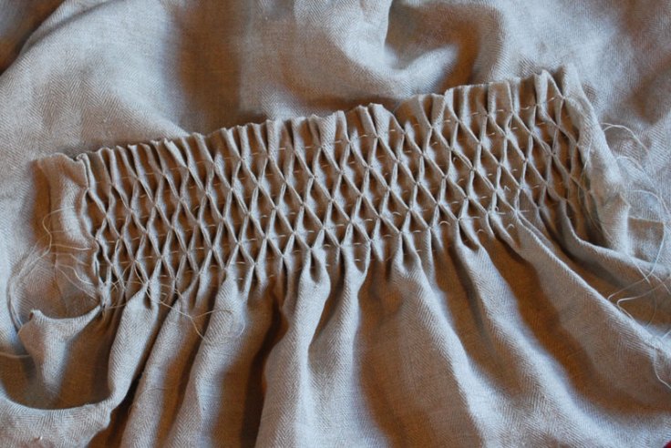 The honeycomb pattern with the gathering thread still left in the fabric.